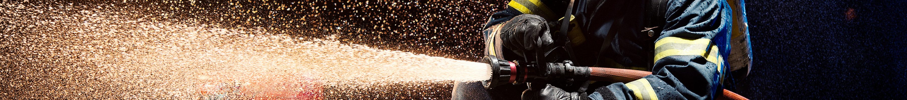 Anonymous fireman fighting fire with water